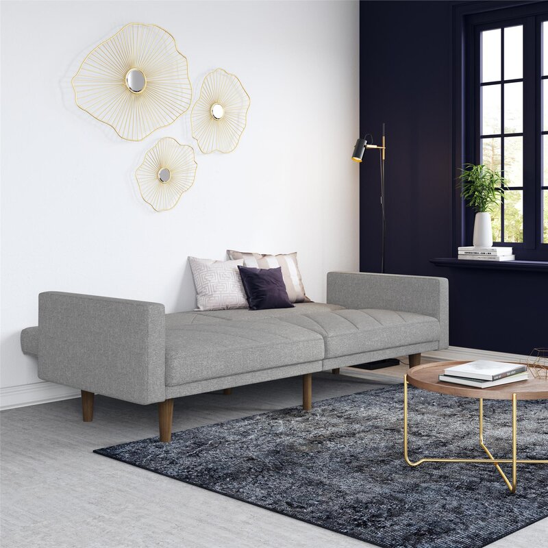 A modern convertible sofa with a wide seat and split backrest in a neutral fabric.