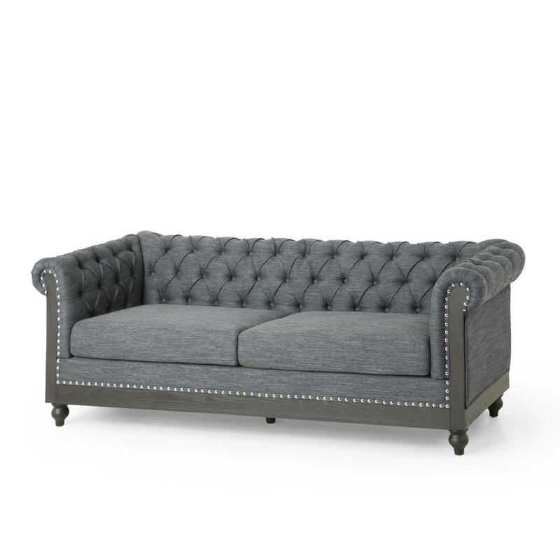 Brown leather Chesterfield sofa with rolled arms and tufted back