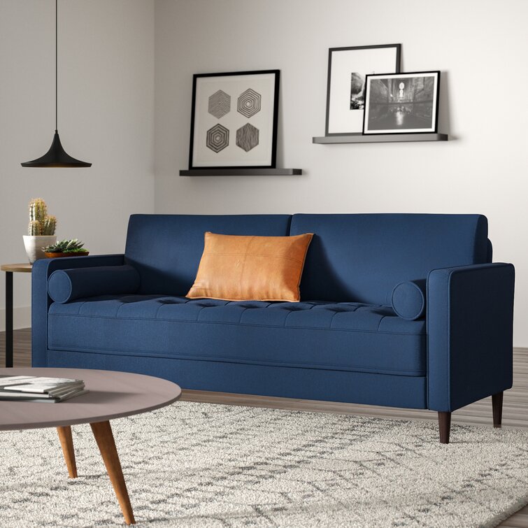 Wide square arm couch in a modern apartment living area.