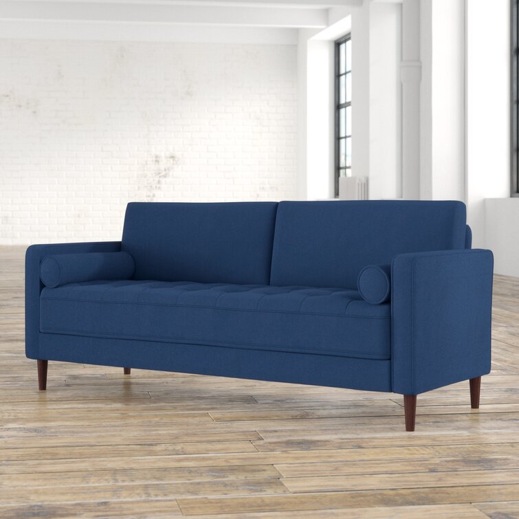 Deep-seated tufted sofa with clean square arms and neutral fabric.