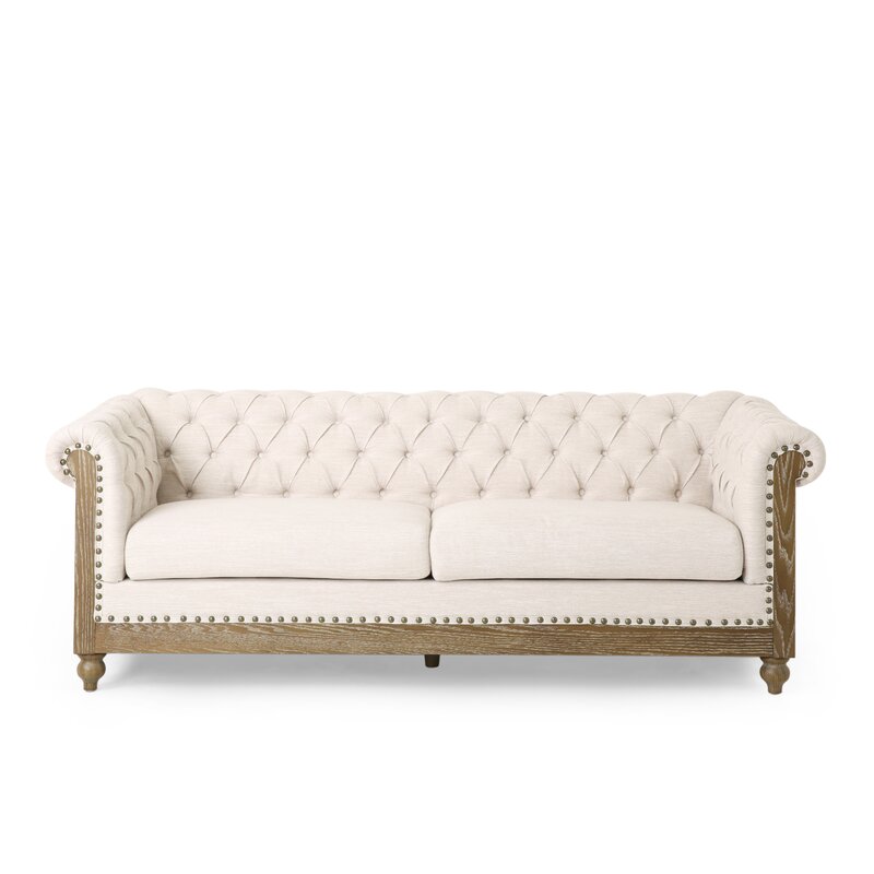 Brown leather Chesterfield sofa with rolled arms and tufted back