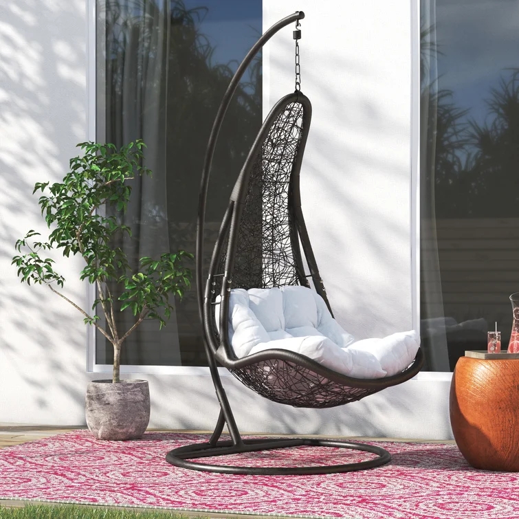 A person sitting comfortably on a wooden porch swing.