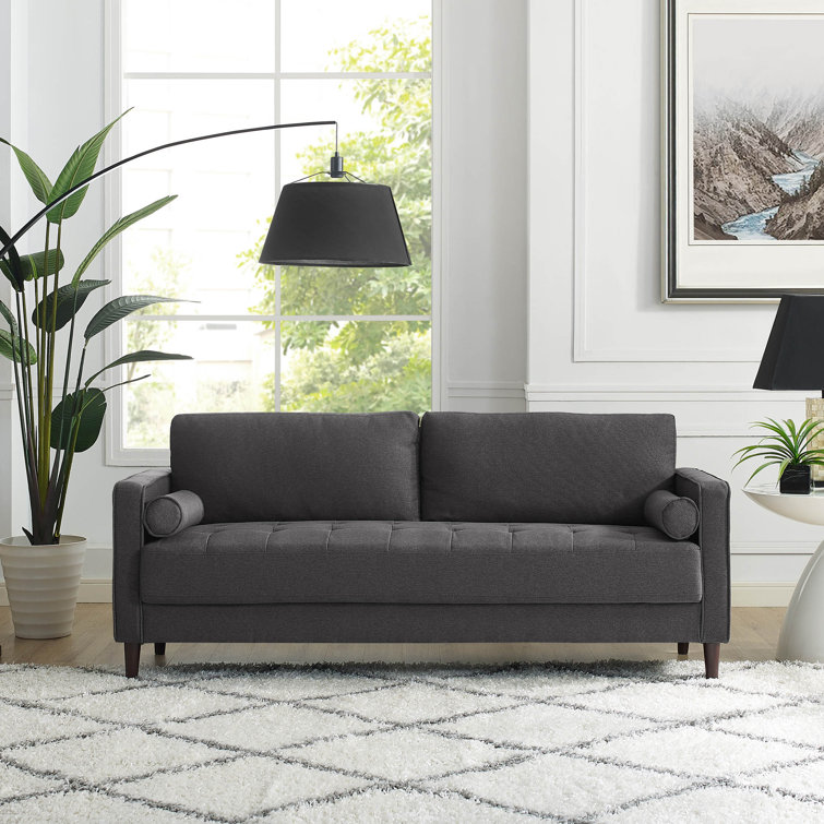Contemporary living room setup featuring a comfortable tufted couch.