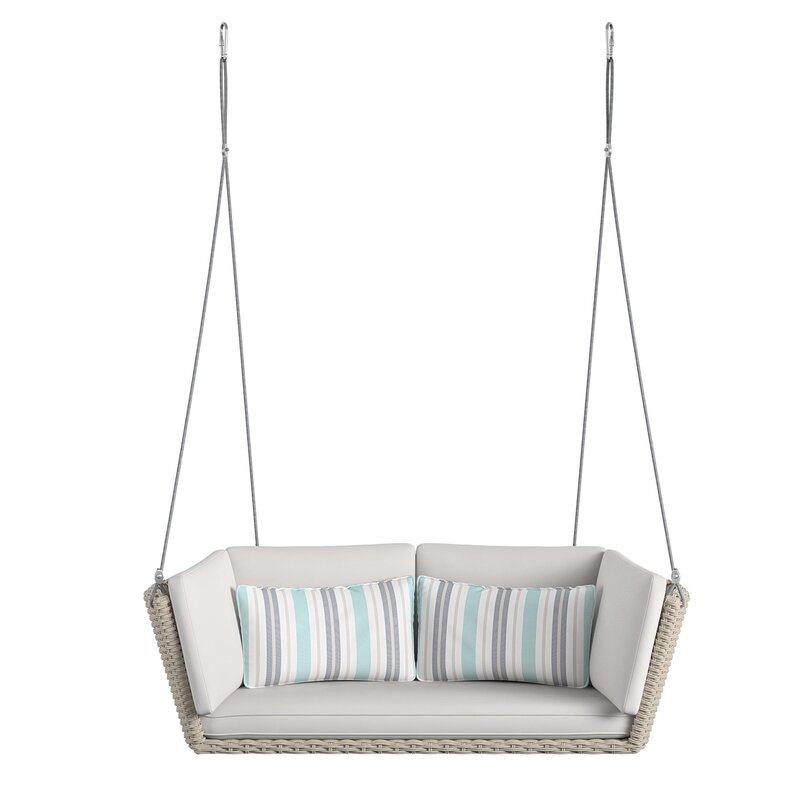 A classic wooden porch swing hanging from a covered patio.