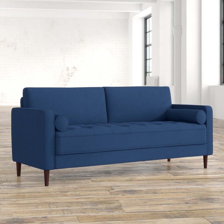 Contemporary living room setup featuring a comfortable tufted couch.