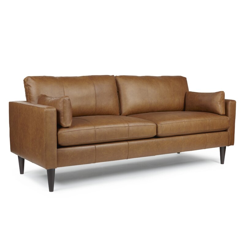 The leather sofa placed in a modern living room next to a coffee table.
