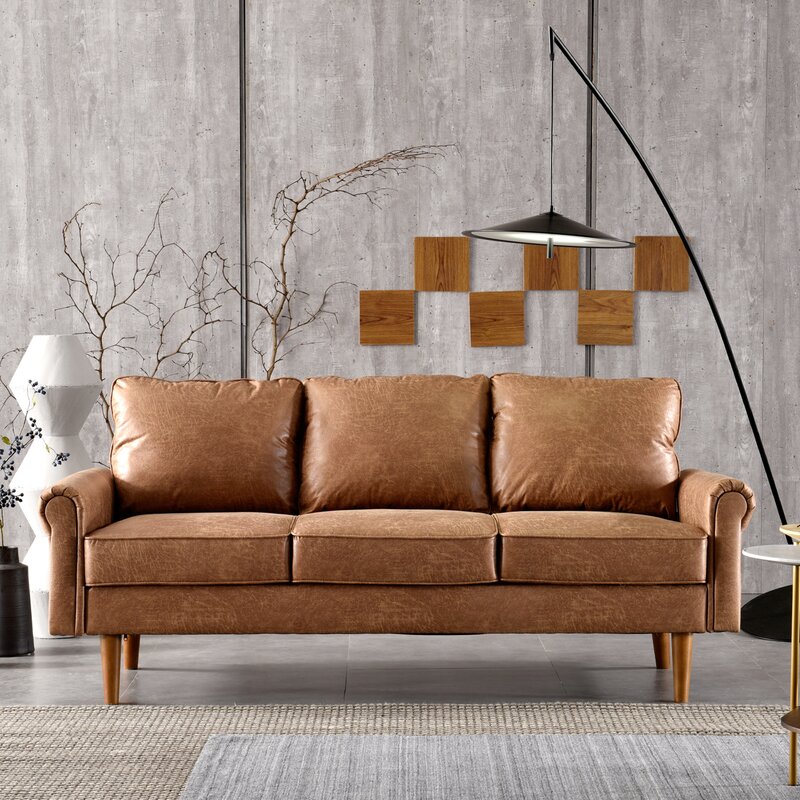 A classic sofa with rolled arms and tapered wooden legs in a neutral fabric.
