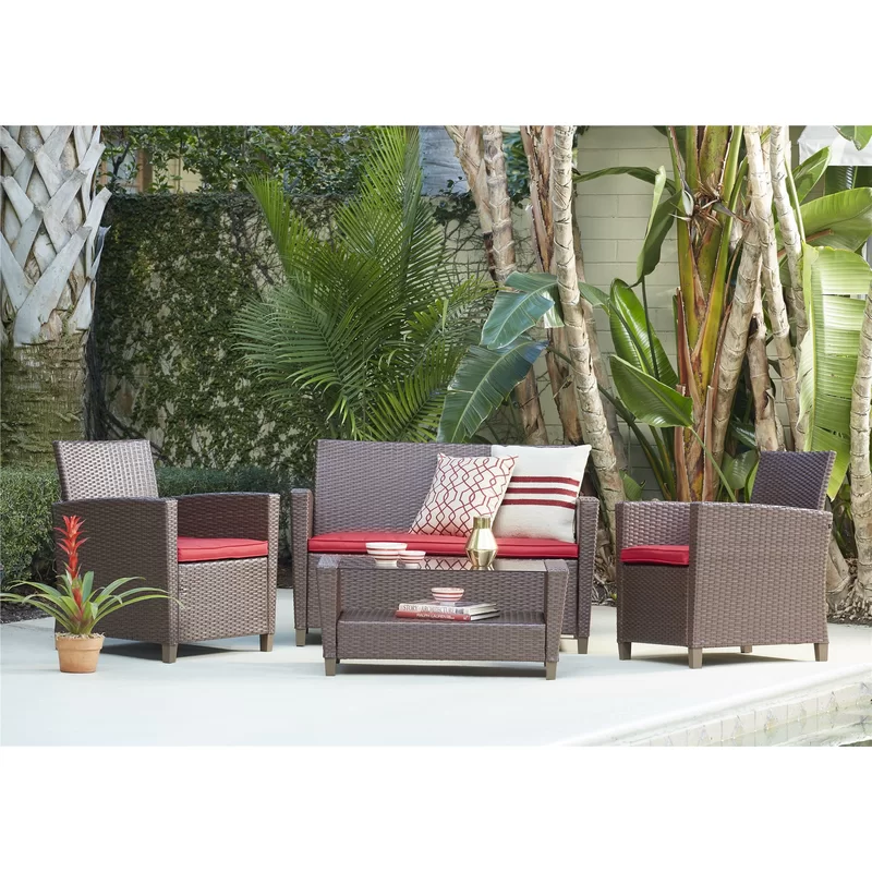 Outdoor wicker lounge set with cushions and coffee table on a stone patio.