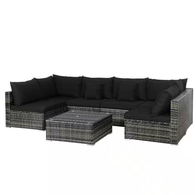 Outdoor wicker patio furniture set with black cushions arranged on a deck