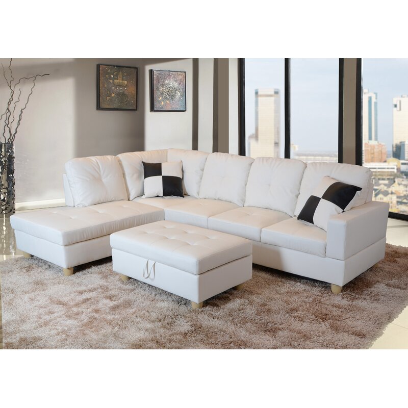 A spacious modern sofa with a chaise lounge in faux leather.