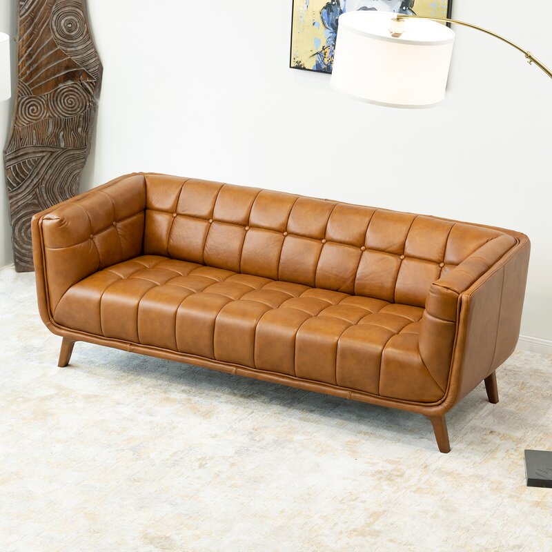 A large brown leather sofa with elegantly curved flared arms.